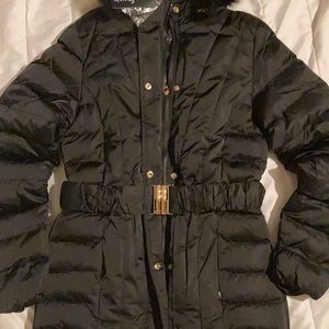 Es un abrigo color negro bonito nuevo